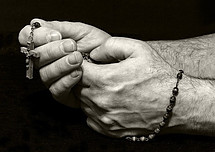 holding rosary while praying