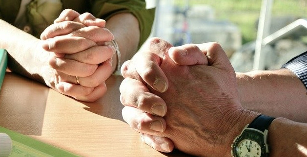 picture of the hands of two people praying together