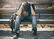 Man sitting on a park bench feeling hopeless
